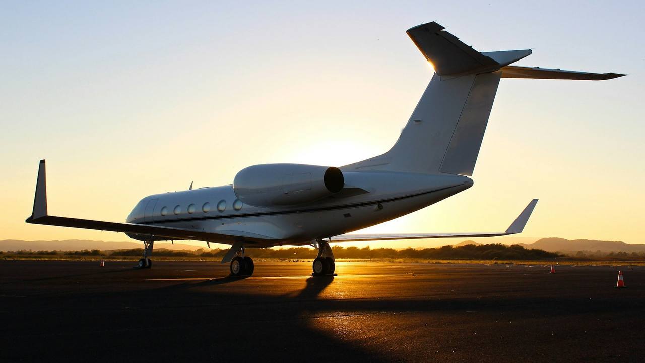 A private jet on the apron at sunset