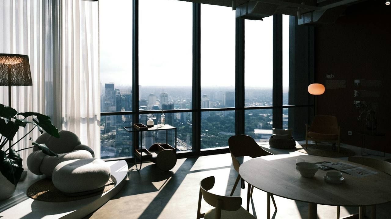 A quiet lounge high above the city, with floor-to-ceiling windows