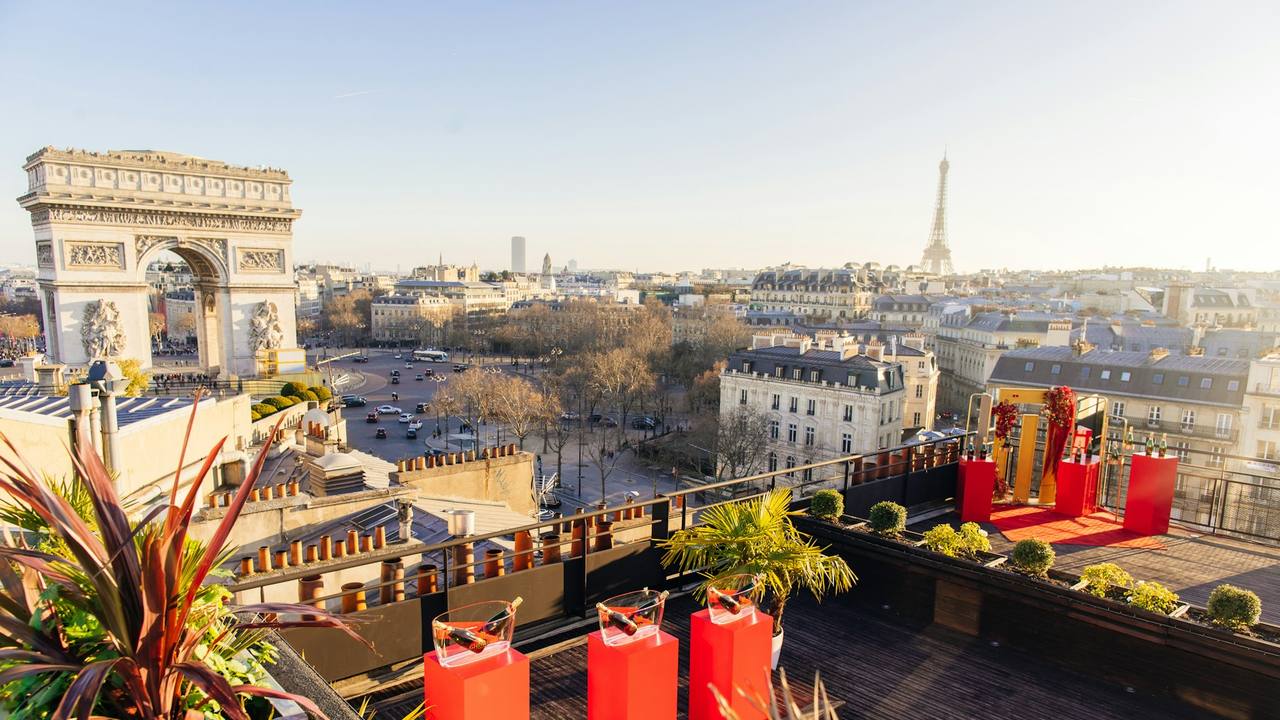 A rooftop terrace above Paris, looking out to the Arc de Triomphe and the Eiffel Tower