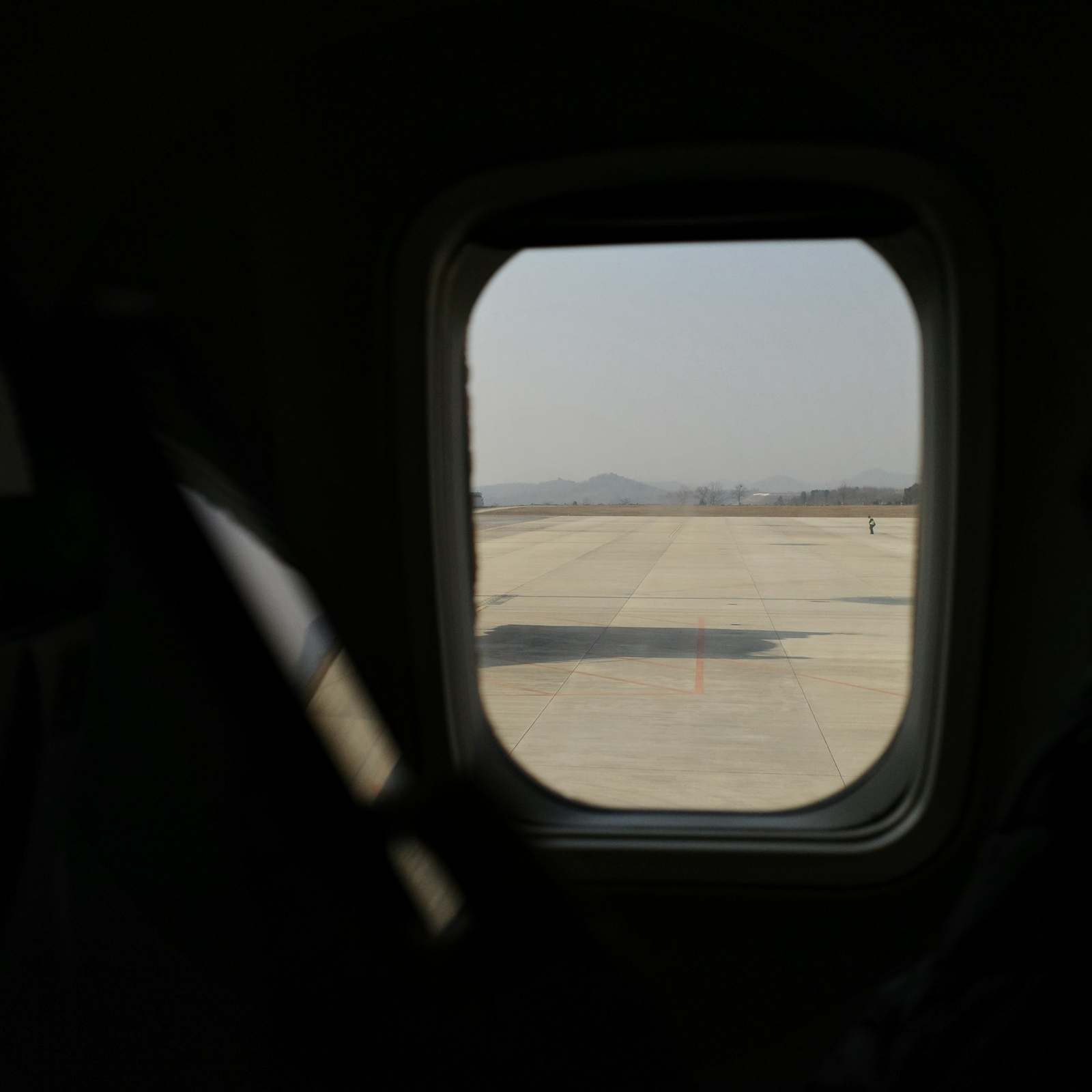 Looking out of an aircraft window at a quiet runway