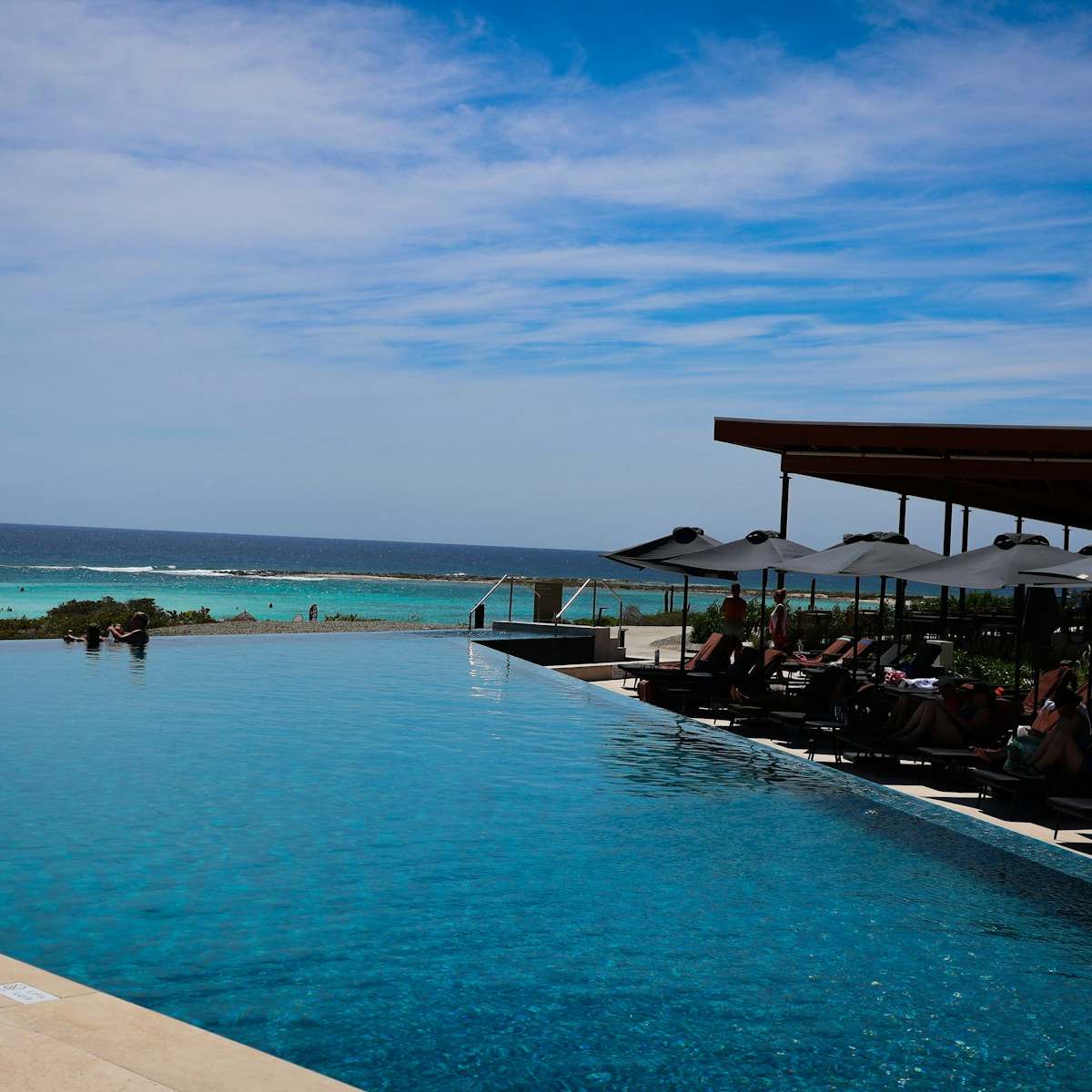 An infinity pool and terrace looking out over the sea