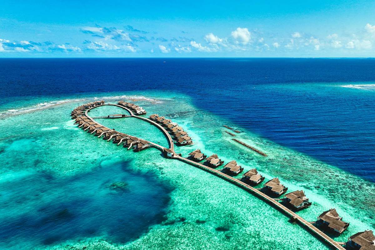 A resort island and its overwater villas, seen from the air