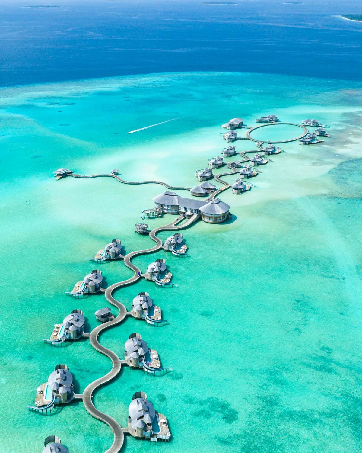 Overwater villas on a turquoise lagoon, seen from above